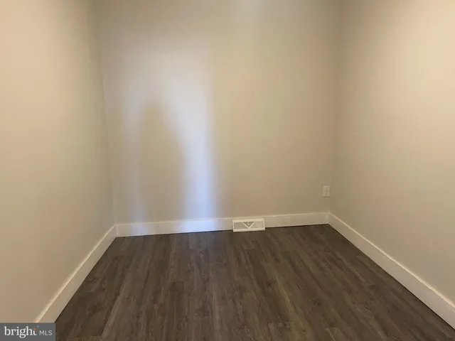 an empty room with wooden floor and closet