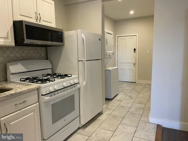 a kitchen with white cabinets and white appliances
