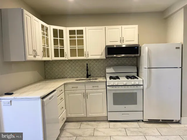 a kitchen with stainless steel appliances granite countertop white cabinets and a stove