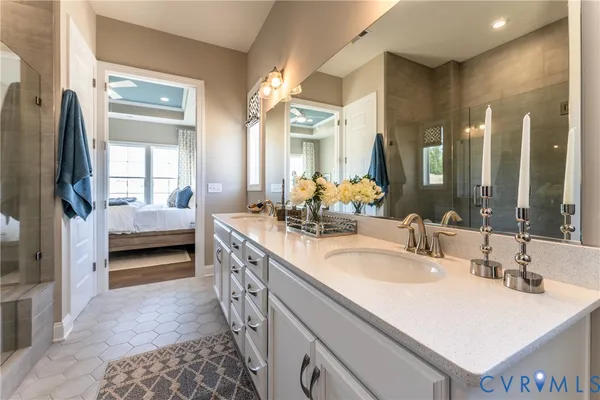 a en suite bathroom with a double vanity sink and a mirror