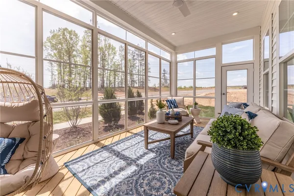 a living room with furniture and a floor to ceiling window