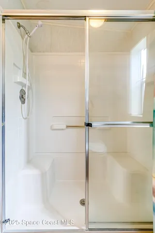 a bathroom with a shower and a glass shower door