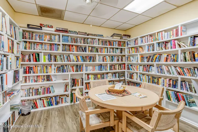 a view of a workspace with furniture and a bookshelf