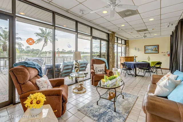 a living room with furniture and a floor to ceiling window
