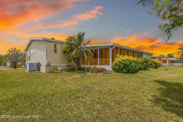 a front view of house with yard and trees in the background