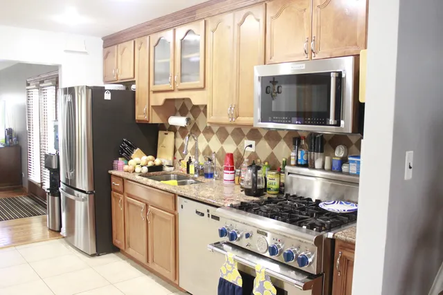 a kitchen with stainless steel appliances granite countertop a stove a refrigerator and a microwave