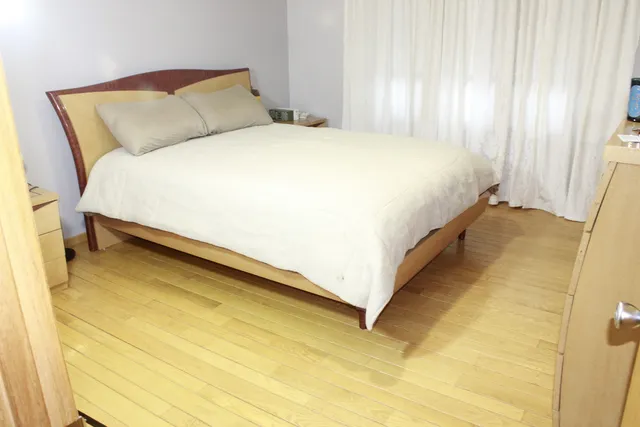 a bedroom with a bed chair and windows