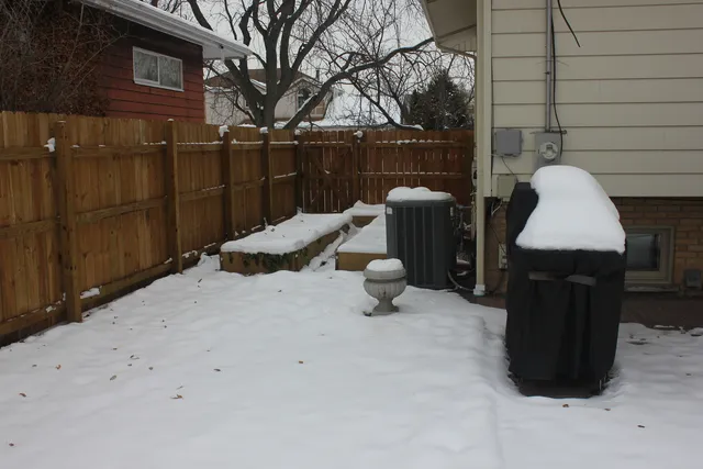 a view of backyard with barbeque grill and wooden fence