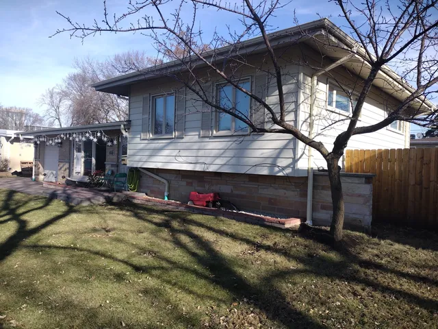 a view of a house with a yard and wooden fence