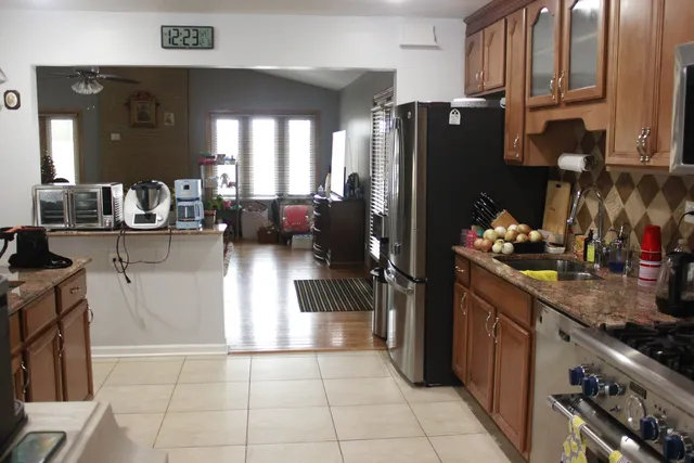 a kitchen with stainless steel appliances granite countertop a refrigerator and a stove