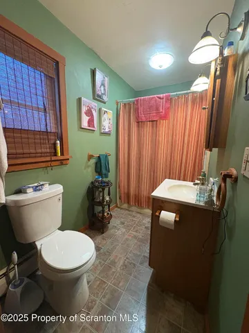 a bathroom with a toilet and a shower curtain