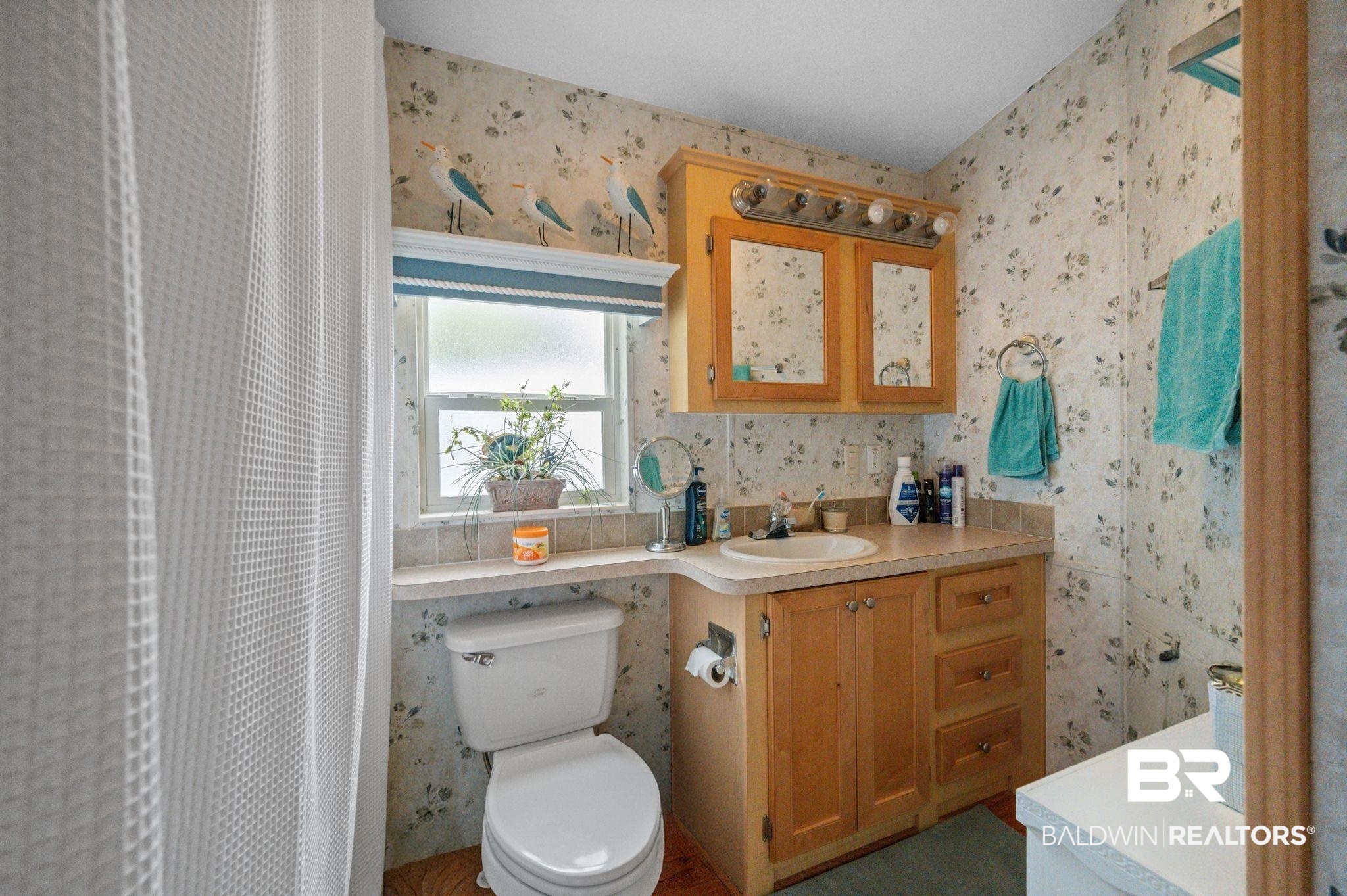 24711 County Road 20, Unit A11 Elberta, AL 36530 - Photo 17 of 35 Full bathroom featuring wallpapered walls, vanity, and a shower with curtain