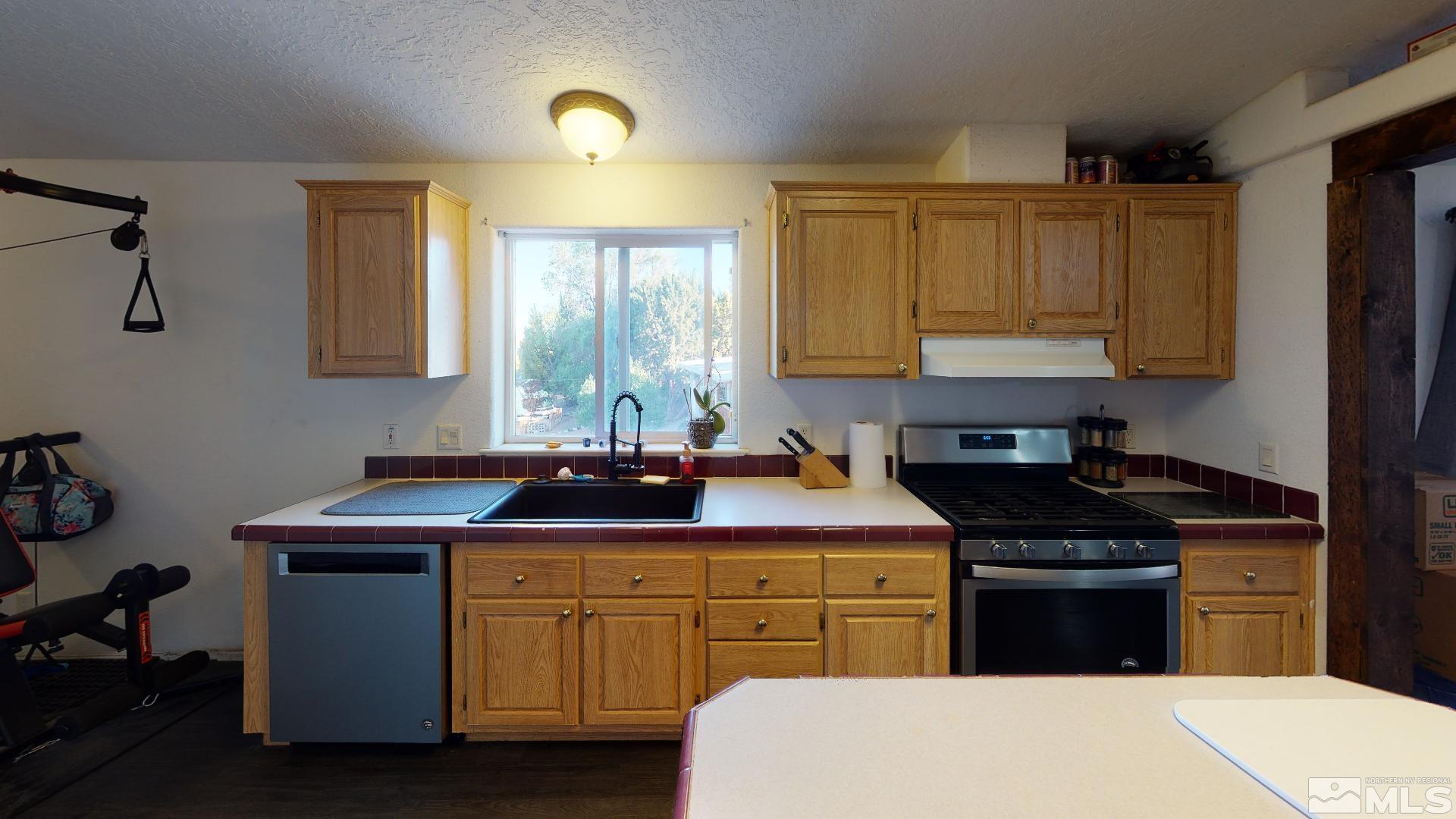 230 Danforth Drive Sun Valley, NV 89433 - Photo 13 of 28 a kitchen with a sink stove and cabinets