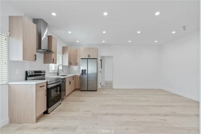 a kitchen with stainless steel appliances kitchen island granite countertop a stove a sink and a refrigerator