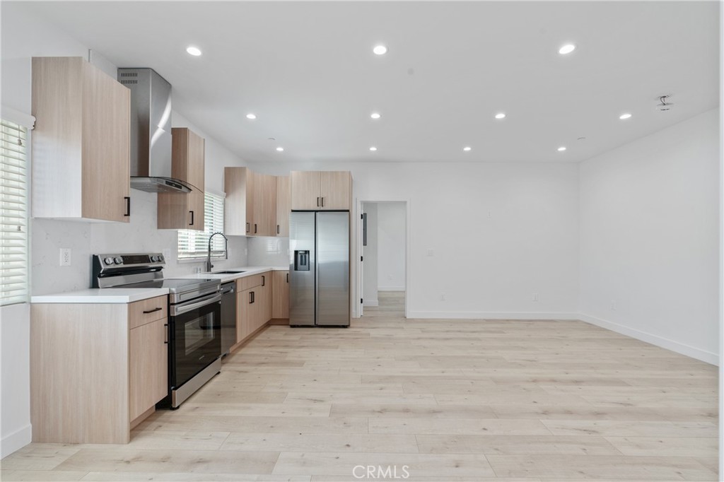 11142 Woodley Avenue Granada Hills, CA 91344 - Photo 2 of 11 a kitchen with stainless steel appliances kitchen island granite countertop a stove a sink and a refrigerator