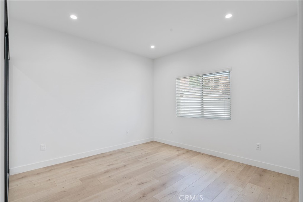 11142 Woodley Avenue Granada Hills, CA 91344 - Photo 7 of 11 an empty room with wooden floor and windows