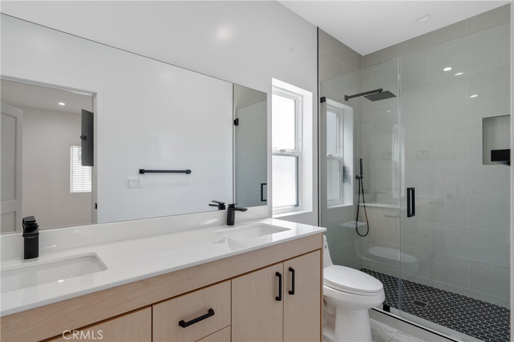 11142 Woodley Avenue Granada Hills, CA 91344 - Photo 8 of 11 a bathroom with a sink toilet a mirror and shower