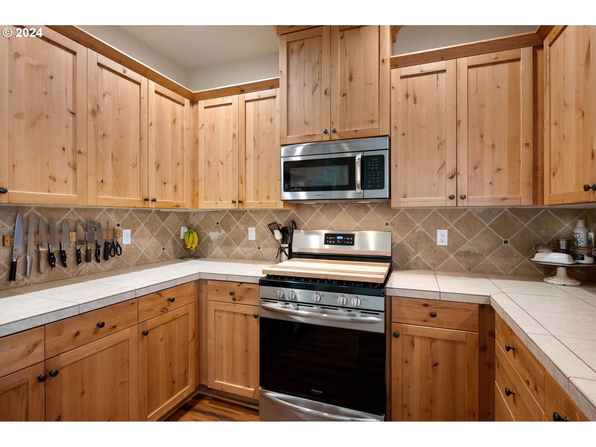 18438 Shadow Ridge Way Oregon City, OR 97045 - Photo 12 of 38 a kitchen with stainless steel appliances a stove a sink a microwave and cabinets
