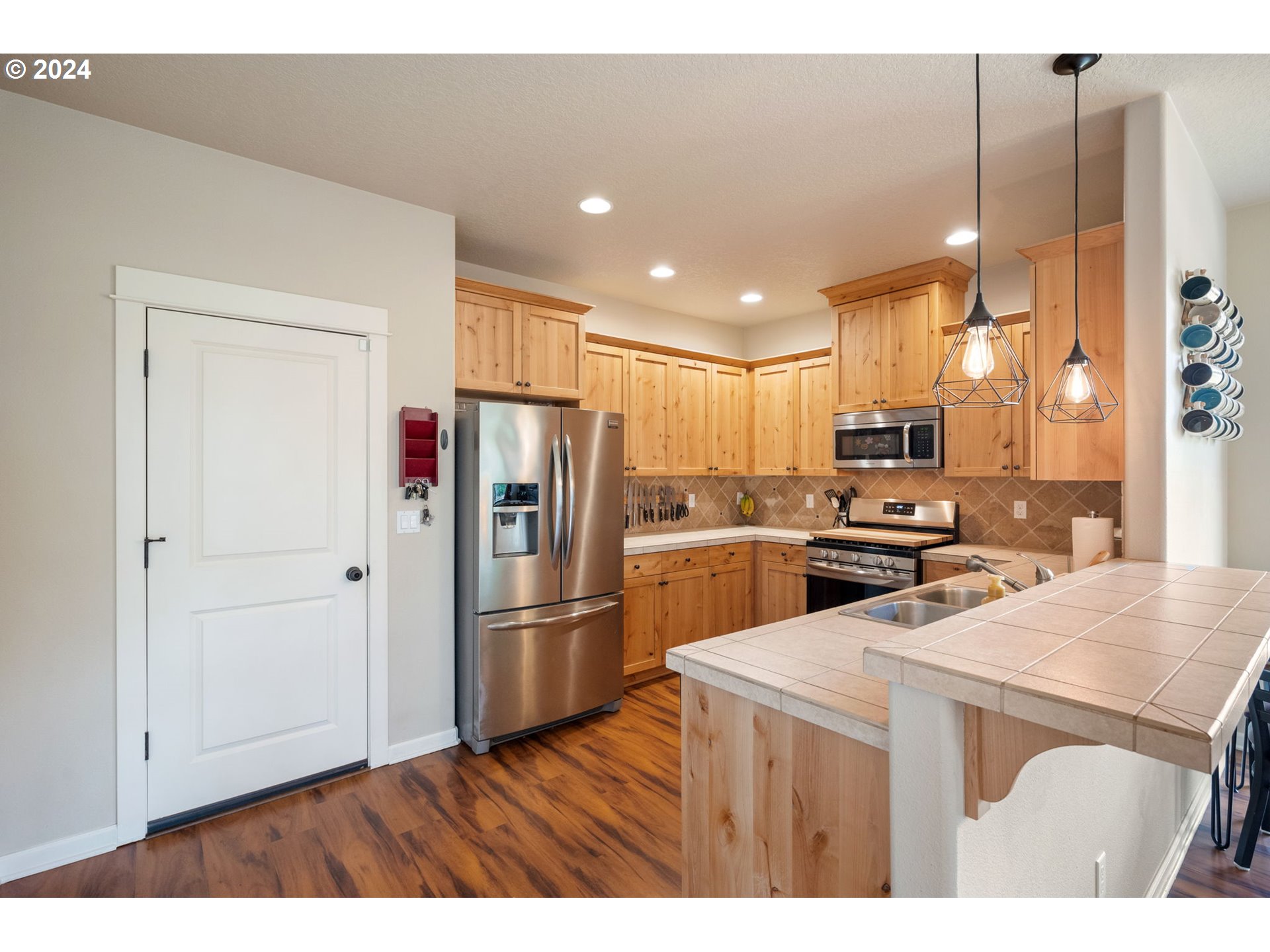 18438 Shadow Ridge Way Oregon City, OR 97045 - Photo 10 of 38 a kitchen view with stainless steel appliances a refrigerator and wooden floor