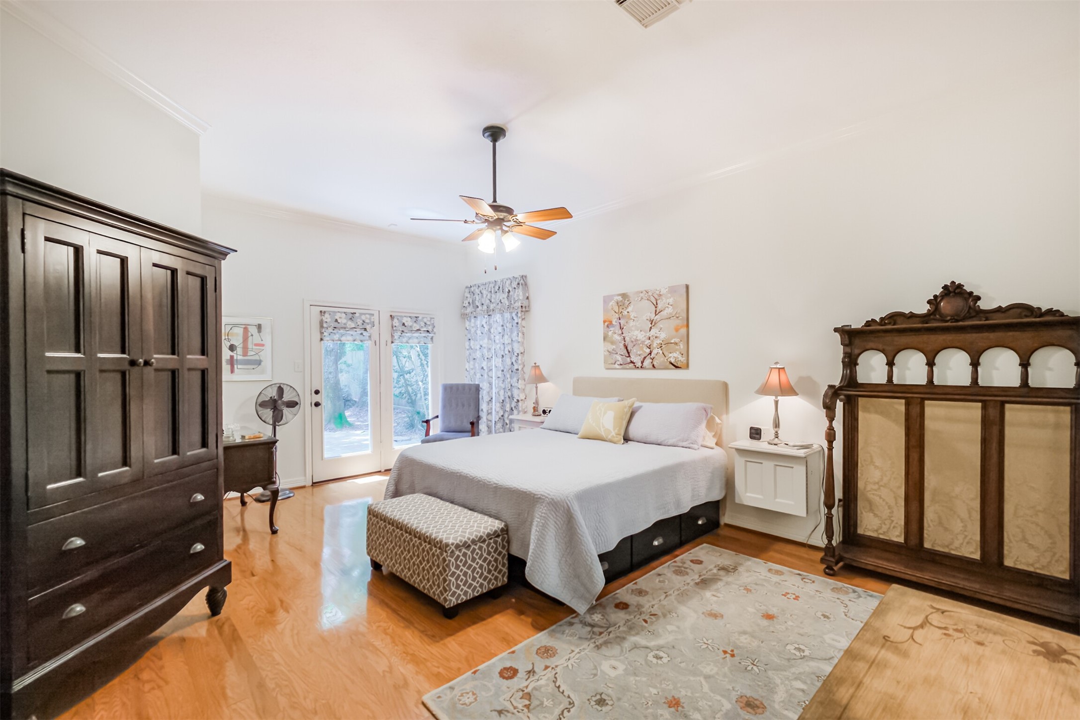 14919 Codys Run Cypress, TX 77429 - Photo 7 of 32 Enjoy first-floor living in this spacious primary suite featuring high ceilings, hardwood flooring, French doors to the patio, and easy access to the remodeled spa-inspired ensuite bath.
