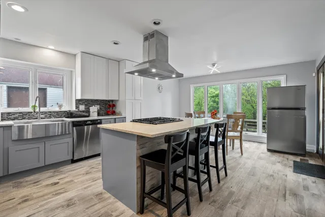 a view of a dining room with furniture a kitchen and chandelier