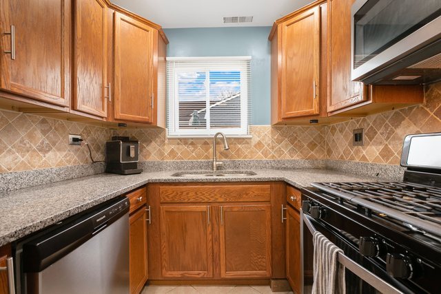172 Oxford Road Bolingbrook, IL 60440 - Photo 6 of 27 a kitchen with granite countertop a sink a stove and cabinets