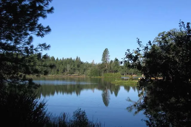 a view of a lake in between two and trees