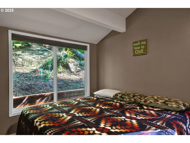 a bedroom with a bed and a large window