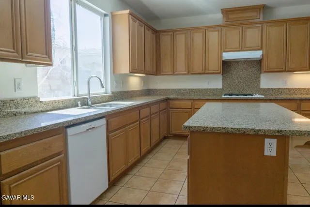 a kitchen with stainless steel appliances granite countertop a stove a refrigerator and a sink