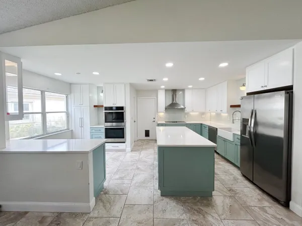 a large kitchen with a large counter top stainless steel appliances and cabinets