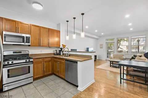 a kitchen with kitchen island granite countertop a stove a sink and a microwave