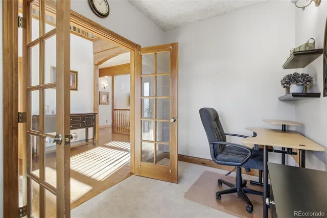 a view of a workspace with furniture and a window