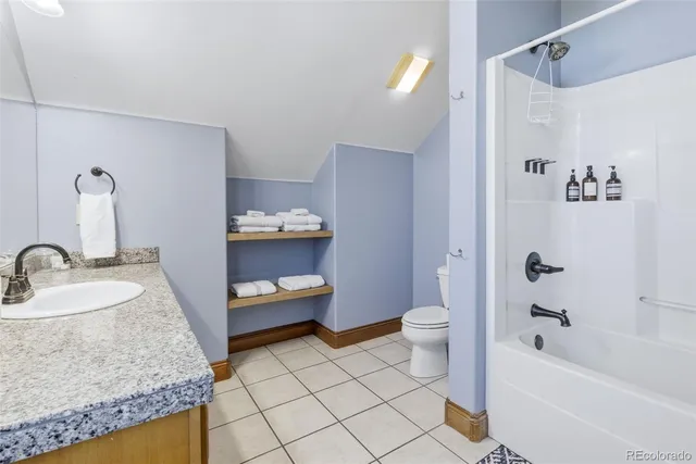 a bathroom with a granite countertop sink a toilet and shower