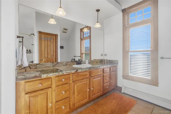 a bathroom with a granite countertop double vanity sink and a mirror