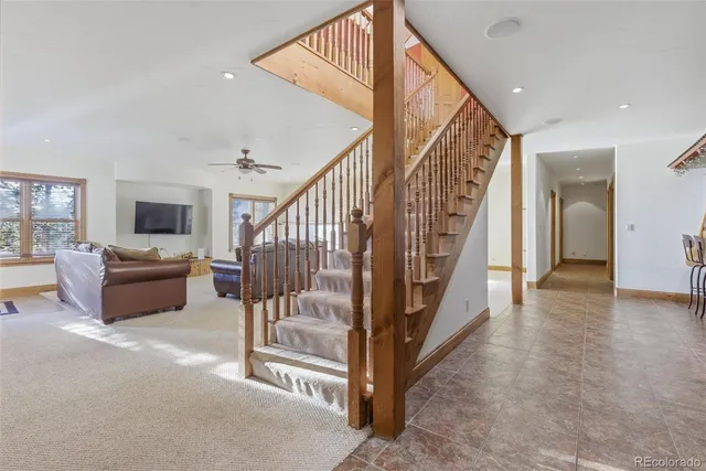 a view of a livingroom with lots of furniture and staircase
