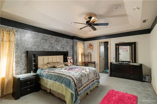 a bedroom with a bed and dresser with mirror