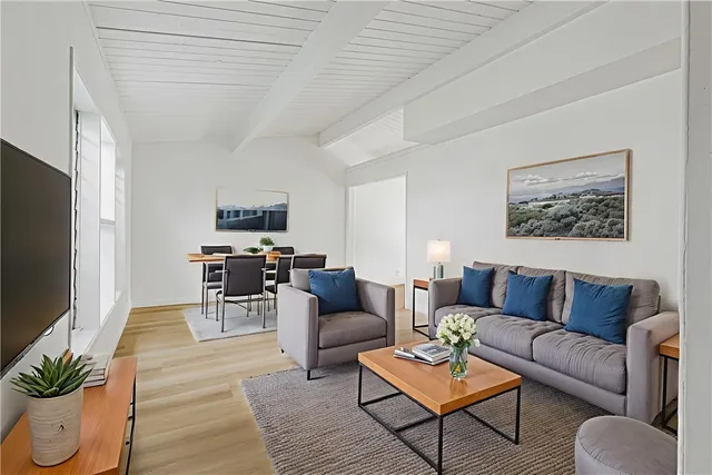 a living room with furniture a flat screen tv and a table