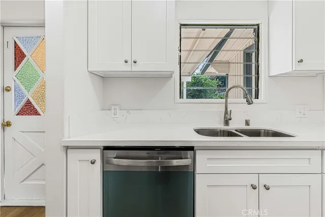 a kitchen with stainless steel appliances granite countertop a sink a cabinets and a window