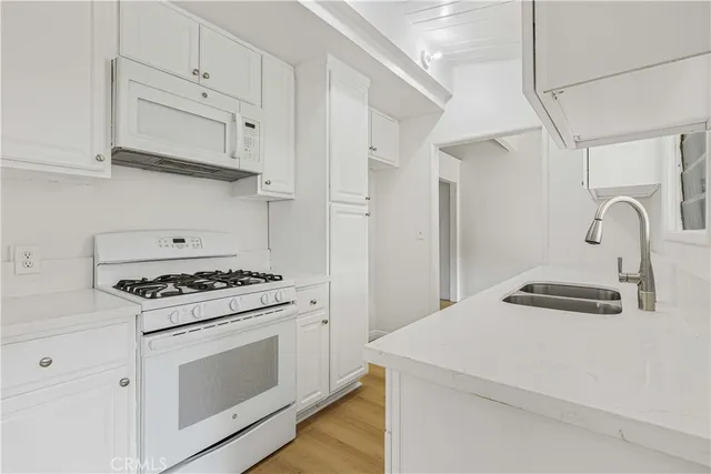 a kitchen with white cabinets stainless steel appliances and sink