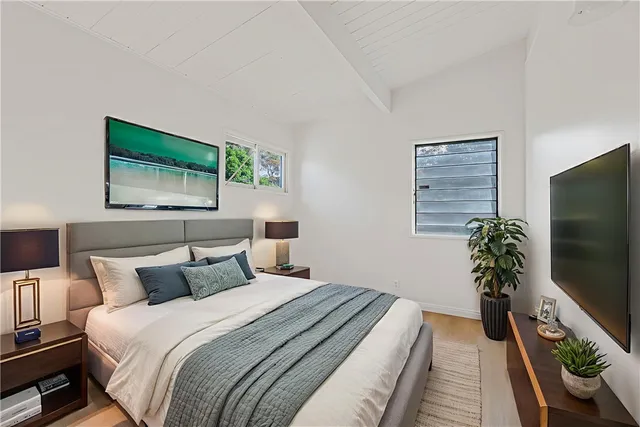 a bedroom with a bed and a flat screen tv
