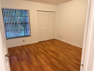 7473 Champagne Place Boca Raton, FL 33433 - Photo 14 of 27 an empty room with a wooden floor and a window