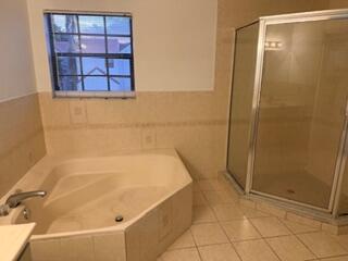 7473 Champagne Place Boca Raton, FL 33433 - Photo 19 of 27 a bathroom with a bathtub and next to a window