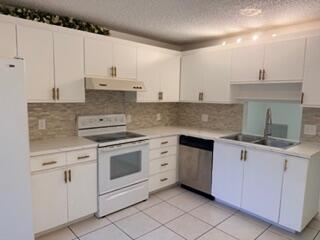7473 Champagne Place Boca Raton, FL 33433 - Photo 5 of 27 a kitchen with cabinets appliances and a sink