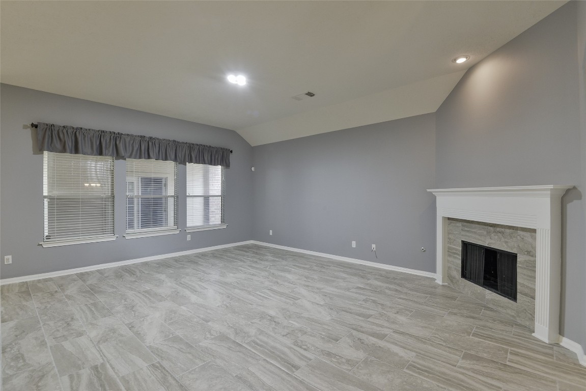 18411 Atasca Wds Trace Humble, TX 77346 - Photo 11 of 44 a view of an empty room with wooden floor and a fireplace