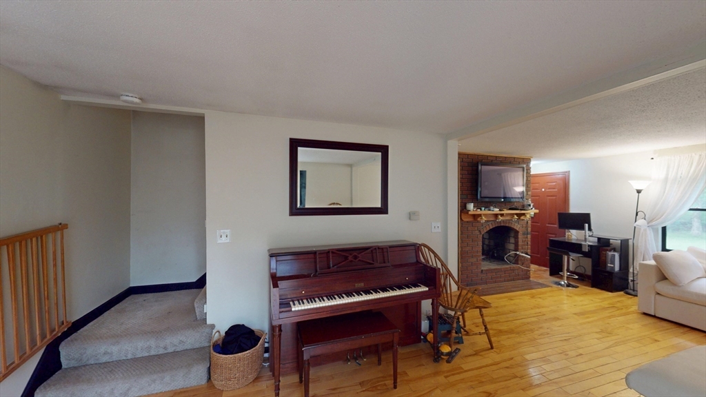 330 Arbor Street Lunenburg, MA 01462 - Photo 16 of 33 a living room with furniture a dining table and a fireplace