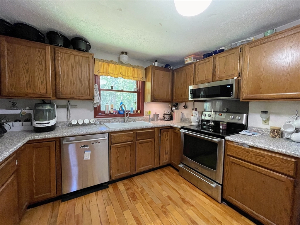 330 Arbor Street Lunenburg, MA 01462 - Photo 8 of 33 a kitchen with granite countertop wooden cabinets a sink a window and stainless steel appliances
