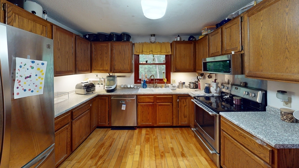 330 Arbor Street Lunenburg, MA 01462 - Photo 9 of 33 a kitchen with stainless steel appliances granite countertop wooden cabinets a stove a sink and a refrigerator
