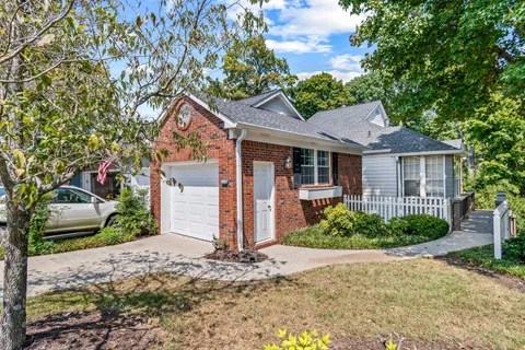 a front view of a house with a yard and potted plants