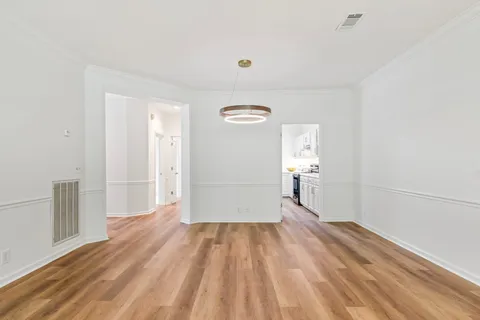 a kitchen with stainless steel appliances white cabinets and wooden floors