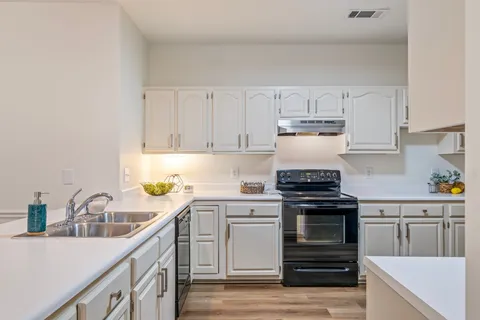 a view of a kitchen with a sink and cabinets